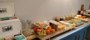 Un bufé de desayuno con diversas opciones de comida y bebidas, como frutas, pasteles y té.