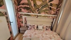 A bedroom with a floral-patterned bedspread, a headboard, and a nightstand with a vase. - 3 minutes from MAYA-MAYA (batignole) airport, secure residential area. (Moungali)