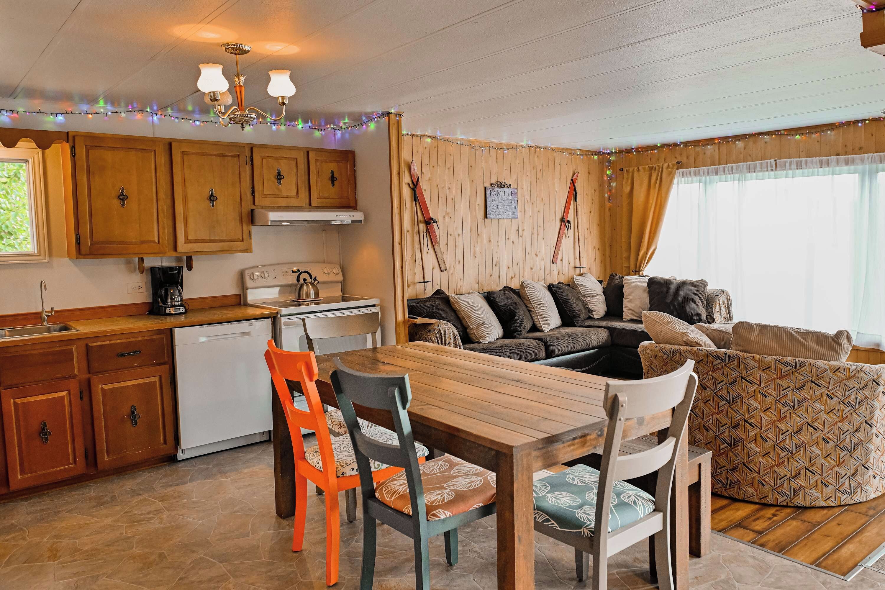 A cozy kitchen with wooden cabinets, a dining table, and a sofa.