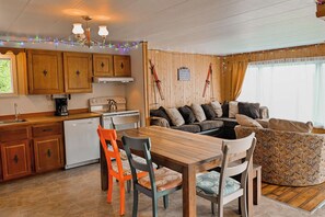 A cozy kitchen with wooden cabinets, a dining table, and a sofa. - Double House - Mont-Video (Barraute)