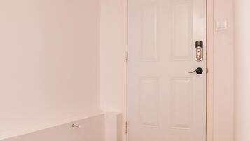 Una scala che conduce a una porta bianca con una serratura a chiave.