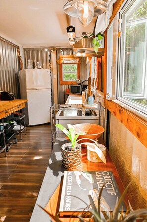A compact kitchen with a refrigerator, microwave, and wooden cabinets.