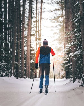 Una persona esquiando por un sendero nevado en un bosque.