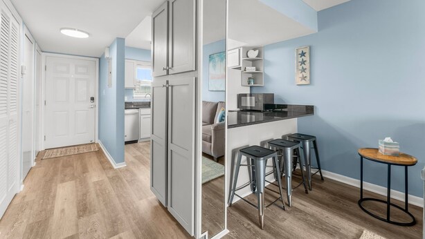 Een moderne keuken met een centraal eiland, barstoelen en een kleine ronde tafel.