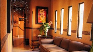 A lobby with a sofa, a vase with flowers, a framed picture, and a staircase. - Habitación doble en Paraíso del Sur (Cuernavaca)