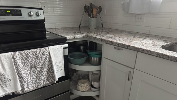 A kitchen with a stove, oven, and a spice rack.