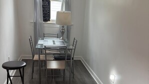 A dining area with a table, chairs, a lamp, and a bean bag chair.