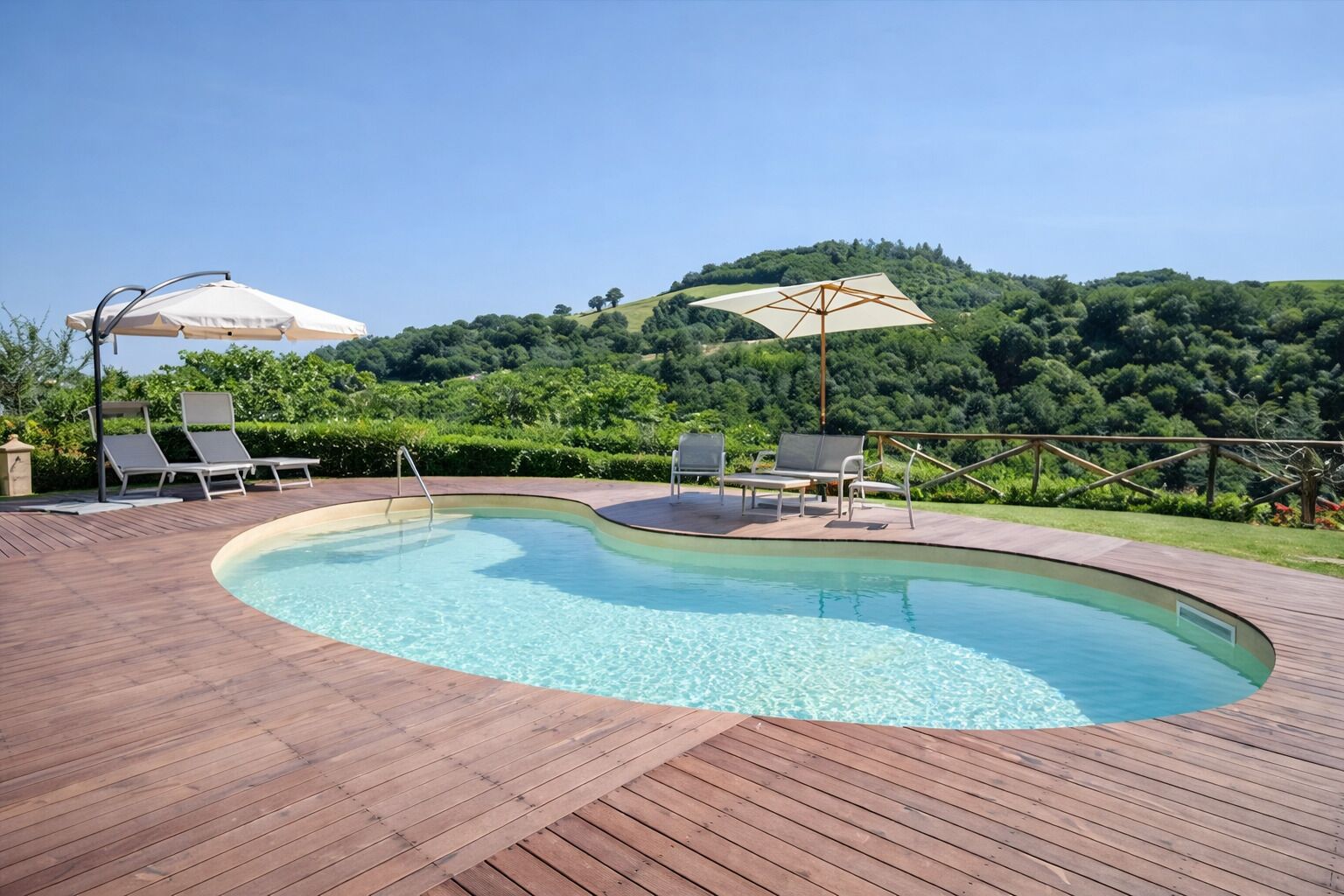A swimming pool with wooden decking, lounge chairs, and umbrellas.