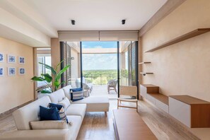 Een moderne woonkamer met een bank, stoelen, een salontafel en uitzicht op de omgeving.