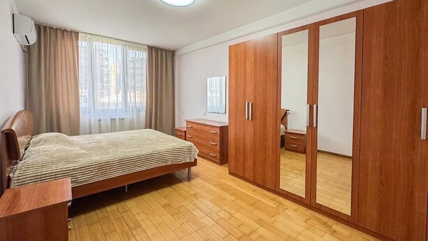 Une chambre à coucher avec un lit, une armoire en bois et un bureau.