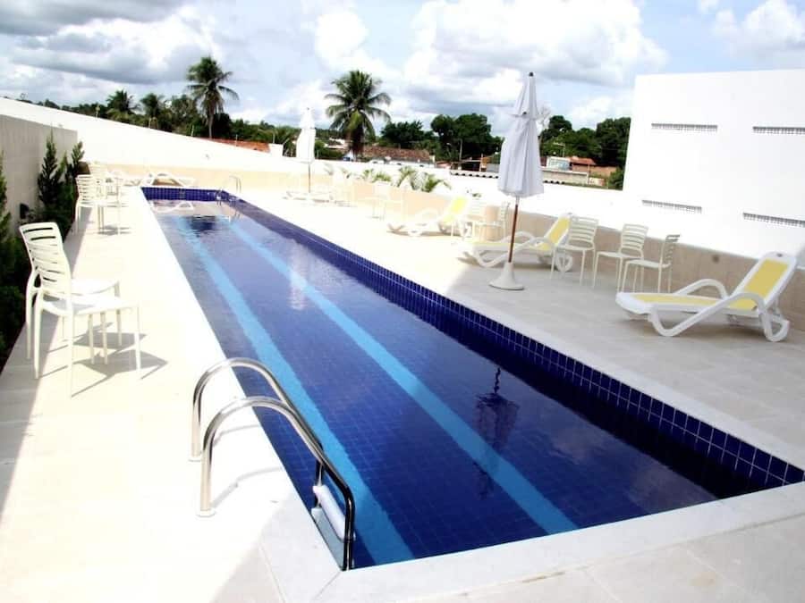 Una piscina al aire libre, sillones reclinables de piscina