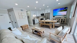 Una sala de estar moderna con sofá, mesa de centro y televisor montado en la pared.