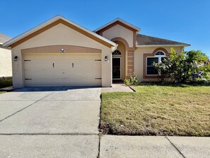 A residential house with a beige garage, a number 1709, and a well-maintained lawn. - Spacious Retreat with Contemporary Comfort (Brandon)
