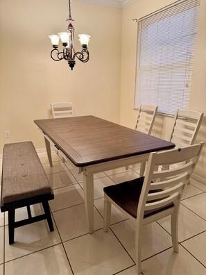 A dining area with a rectangular table, six chairs, a bench, and a chandelier. - Spacious Retreat with Contemporary Comfort (Brandon)