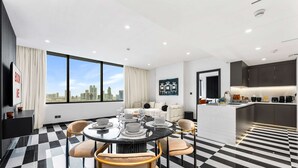 Una habitación de hotel moderna con comedor, sala de estar y cocina.
