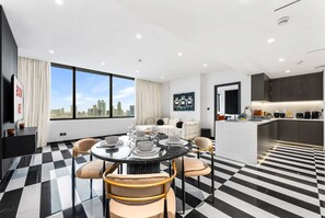 Ein modernes Hotelzimmer mit Essbereich, Wohnbereich und Küche.