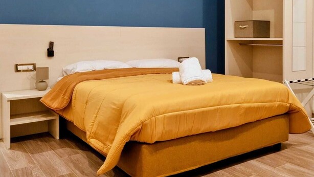 A hotel room with a bed, a nightstand, a wardrobe, and a mirror. - Casa Maluma - Double Room with Kitchenette in the Heart of Naples (Napoli)