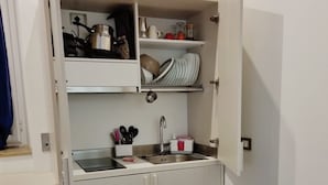 A compact kitchenette with a sink, storage cabinets, and a countertop. - Casa Maluma - Double Room with Kitchenette in the Heart of Naples (Napoli)