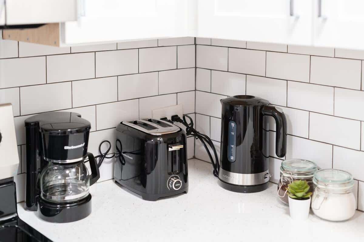 A kitchen with a coffee maker, toaster, and kettle on the counter.
