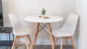 A small, round white table with two white chairs, a small potted plant, and coasters on the table. - King Bed | Close to Chase Field (Phoenix)