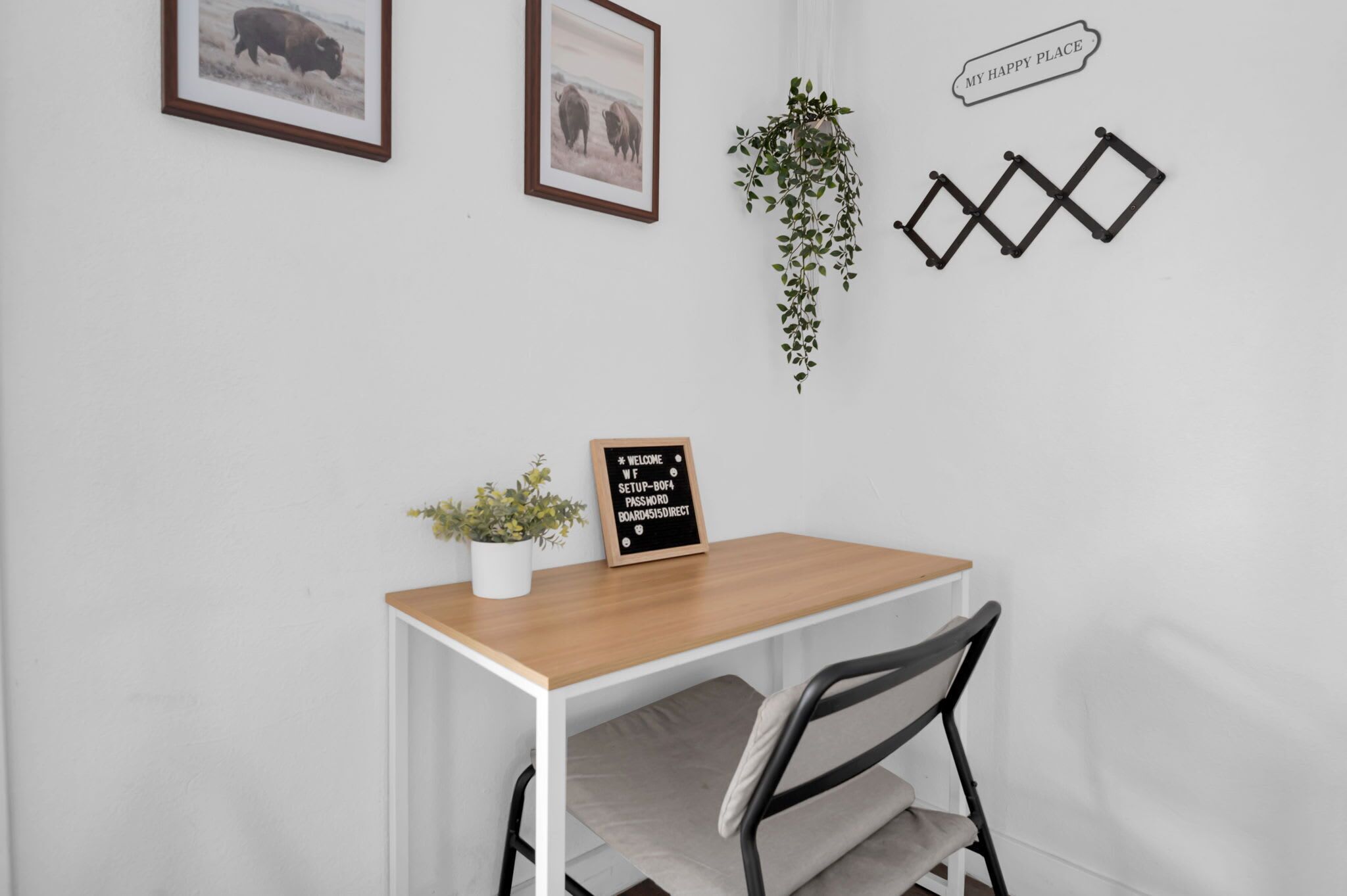 A small, neatly arranged workspace with a desk, chair, and a welcome sign.