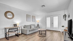 A modern living room with a sofa, coffee table, and TV stand. - King, Parking | Steps from Phoenix Art Museum (Phoenix)