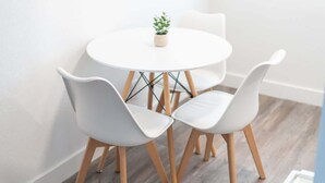 A small round table with two white chairs and a small potted plant. - King, Parking | Steps from Phoenix Art Museum (Phoenix)
