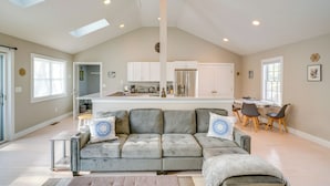 A spacious living area with a grey sectional sofa, a dining table with chairs, and a kitchen in the background. - 6 Mi to Tanglewood! High-End Lee Apartment (Lee)