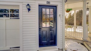 A house with a dark blue front door, white siding, and a porch with a hanging planter. - 6 Mi to Tanglewood! High-End Lee Apartment (Lee)