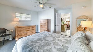 A bedroom with a bed, dresser, chair, and ceiling fan. - Water Access + Beach Area: Crooked Lake Escape (Babson Park)