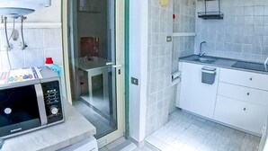 A compact kitchen with a built-in microwave, a sink, and a small countertop. - Cappuccini apartment a few minutes walk from the center (Cagliari)