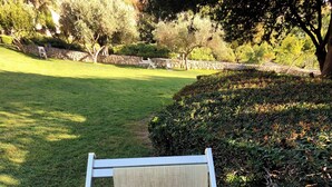 A chair with a sign that reads "Orto dei Cappuccini Cagliari" in a garden setting. - Cappuccini apartment a few minutes walk from the center (Cagliari)