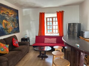 A living room with a red sofa, a coffee table, and a bar area. - 6-BR/9-Bed House-3Min Walk to Plaza de Armas Cusco (Cusco)