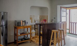 A compact kitchen with a refrigerator, microwave, sink, and bar stools. - 6-BR/9-Bed House-3Min Walk to Plaza de Armas Cusco (Cusco)
