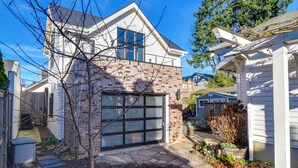 A two-story house with a garage, a brick exterior, and a small garden area. - 2-Story Guesthouse w/ Private Deck in NE PDX (Portland)