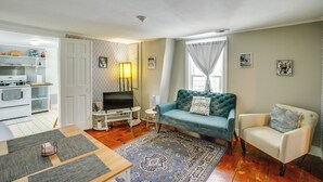 Una sala de estar con sofá, sillón, televisor y una mesita.