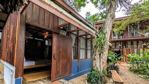 Una casa de madera con un amplio portal abierto, un ventilador de techo y un pequeño porche.