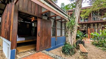 Une maison en bois avec une grande porte ouverte, un ventilateur de plafond et un petit espace de véranda.