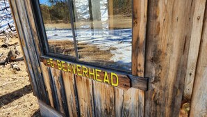 Una cabaña de madera con un cartel que dice "5 Beaverhead".