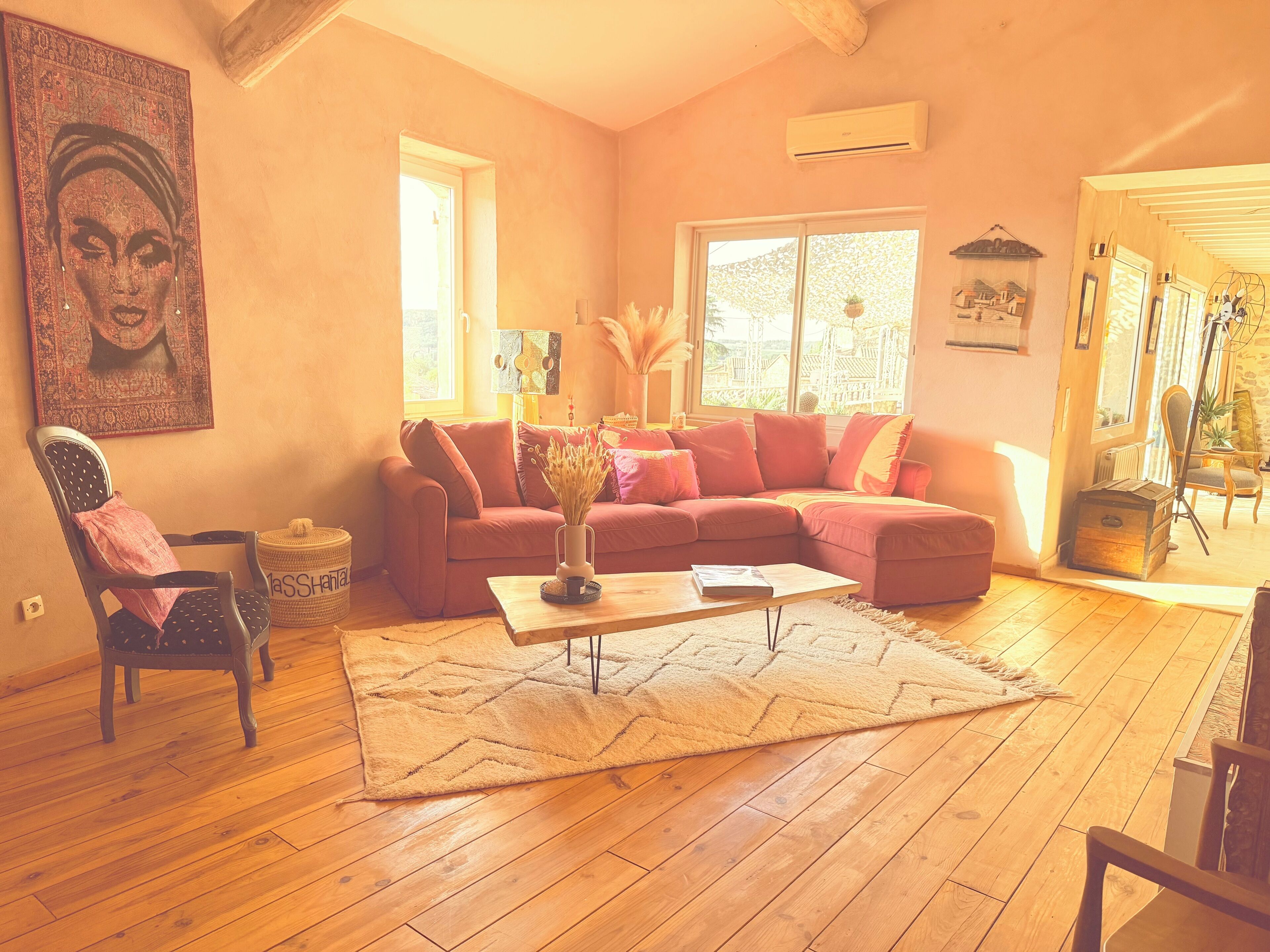 A cozy living room with a sectional sofa, a wooden coffee table, and a large window.