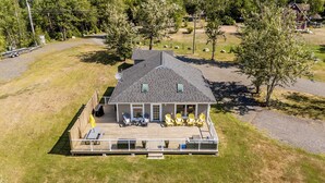 Une maison à deux étages avec une terrasse couverte et une cour clôturée.