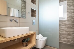 A modern bathroom with a large sink, mirror, and toilet. - Spartakos Villa Resort (Zakynthos)