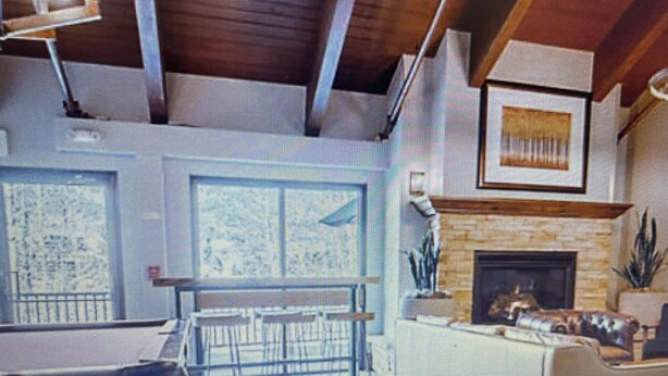 Una sala de estar moderna con chimenea, un comedor y una escalera que sube a un nivel superior.