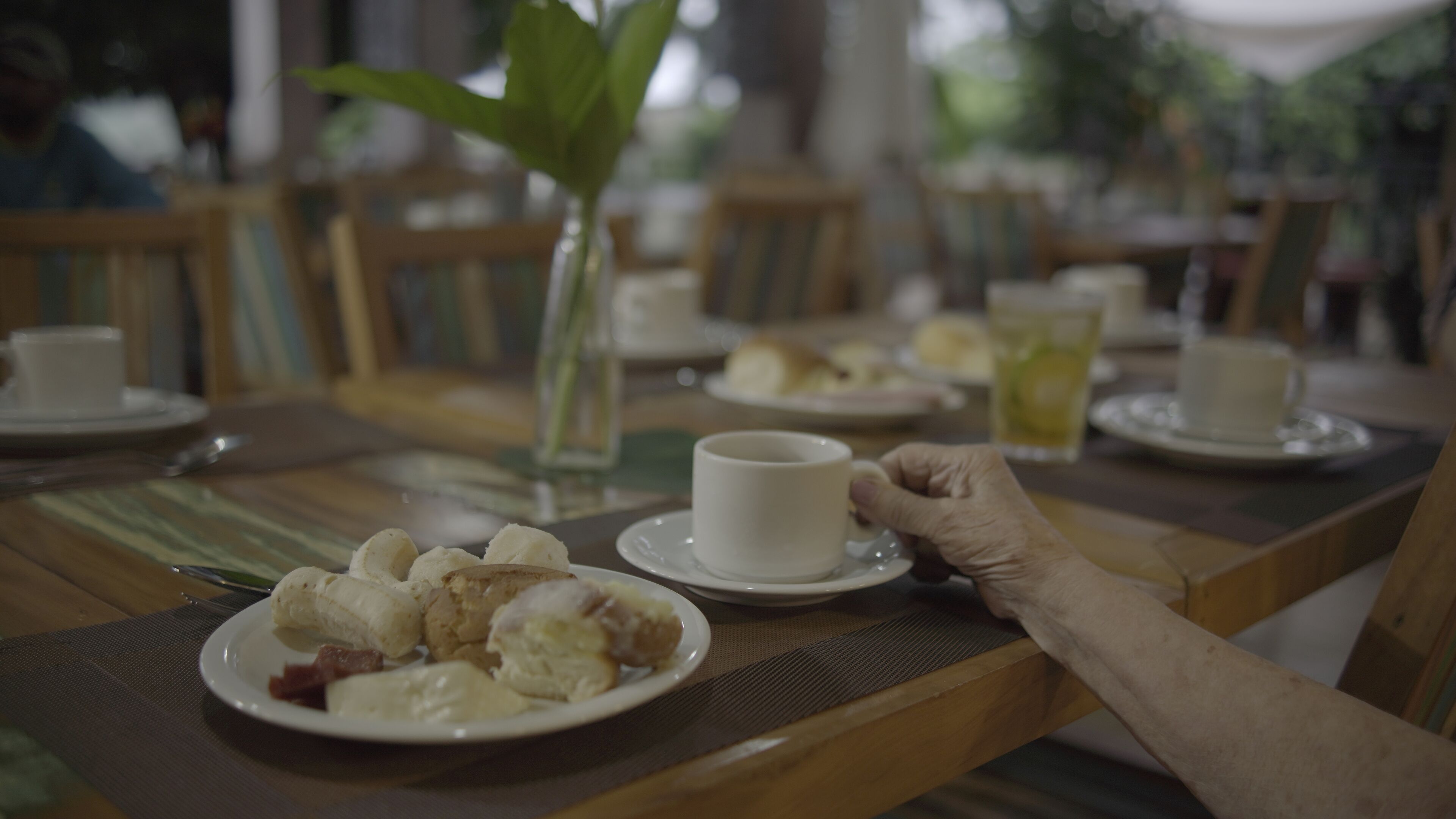 Une table à manger avec des assiettes remplies de nourriture, une tasse et un verre.