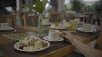 Une table à manger avec des assiettes remplies de nourriture, une tasse et un verre.