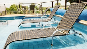 A poolside area with lounge chairs and a table.