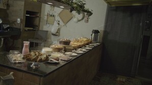A buffet counter with various food items and a coffee machine.