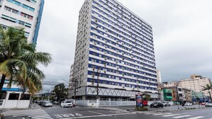Un hotel alto y rectangular con fachada azul y blanca, varios pisos y techo plano.