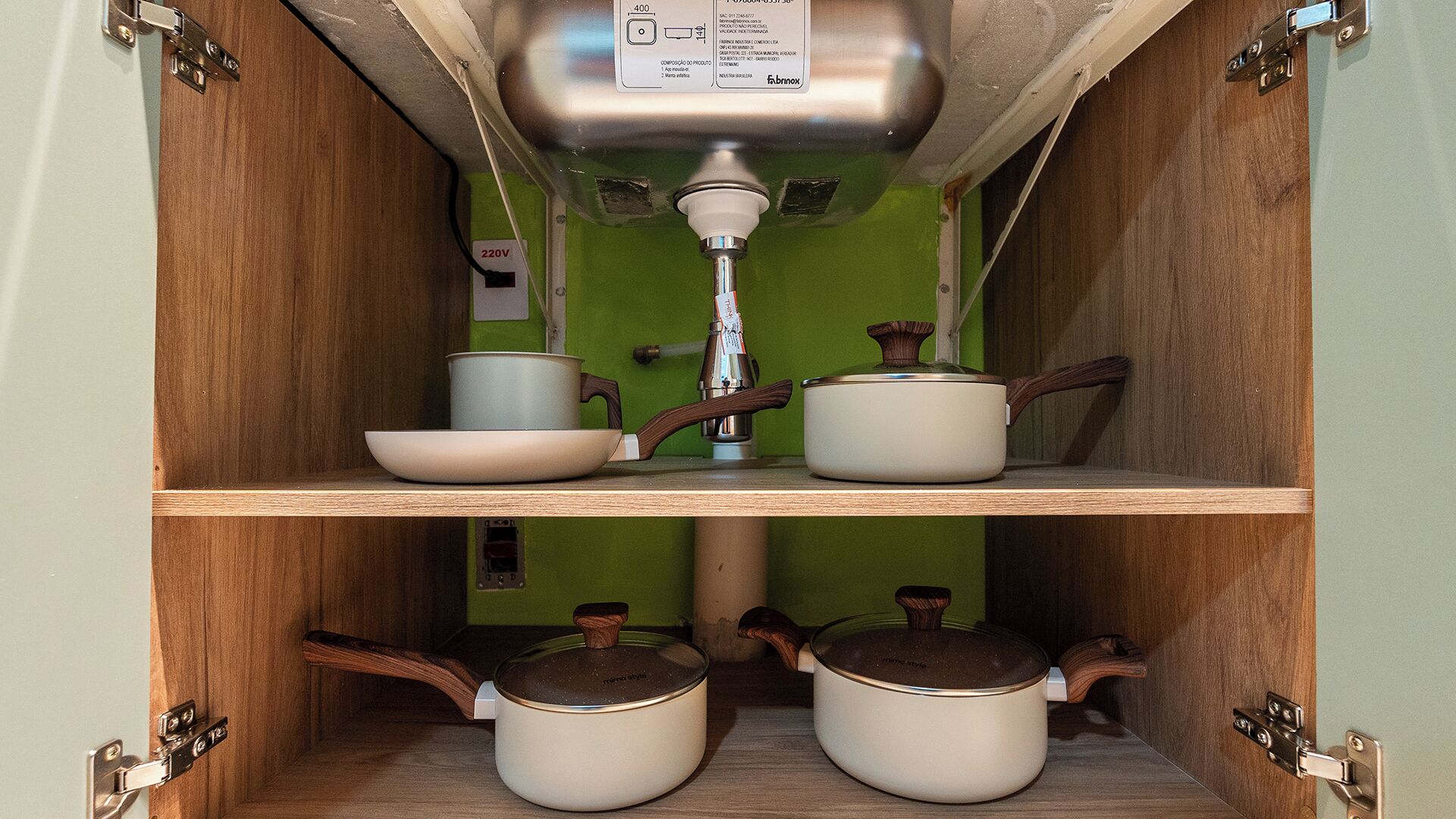 A kitchen with wooden cabinets, a green wall, and a built-in sink with a faucet.