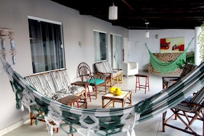Una habitación con hamaca, muebles de mimbre y vistas a la ciudad.